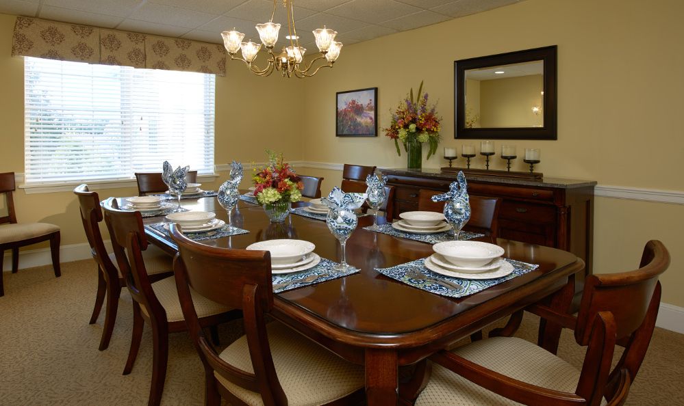 Senior living community at The Village At Willow Crossings featuring elegant dining room with wooden furniture.
