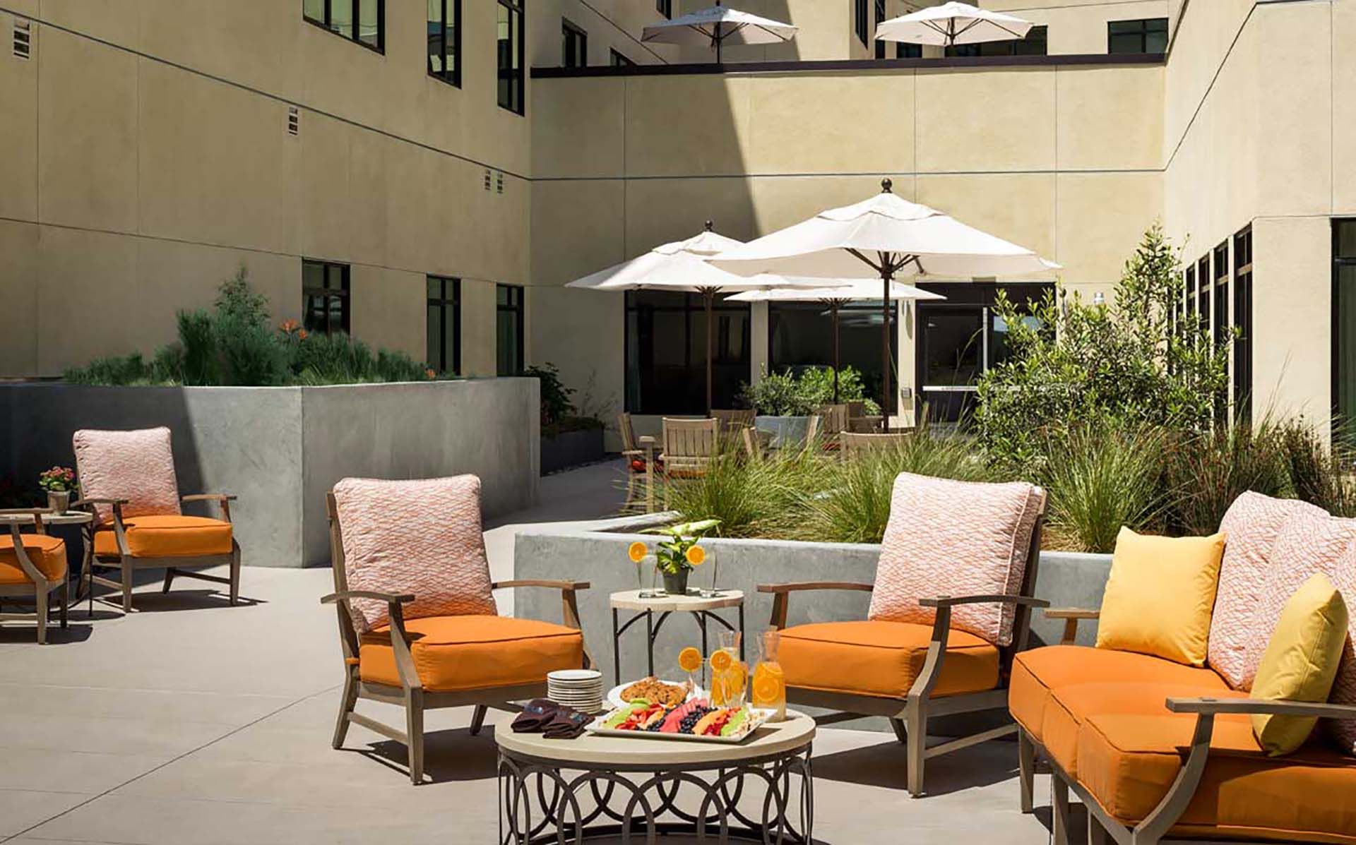 Senior living community, Atria At Foster Square, featuring modern architecture and cozy patio furniture.