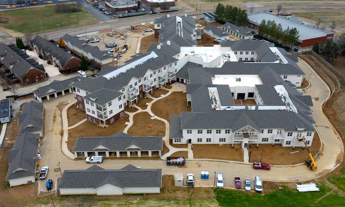 Aerial view of HarborChase of Cordova senior living community with houses, vehicles, and driveway.