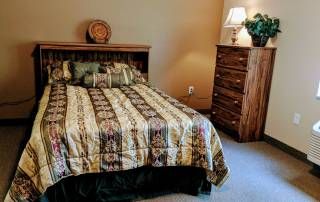 Senior living room at Courtyard Estates of Knoxville with cozy bedroom furniture and home decor.