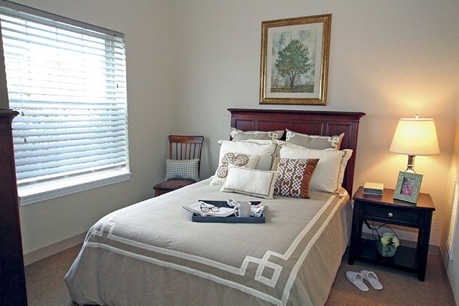 Interior view of a bedroom at Charter Senior Living of Poplar Creek, featuring cozy decor and furniture.