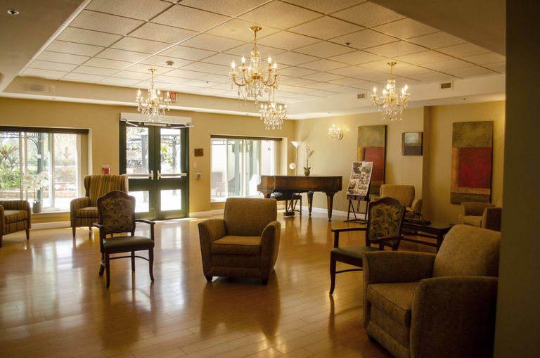 Interior view of Weinberg Village senior living community featuring a piano, chandelier, and elegant decor.