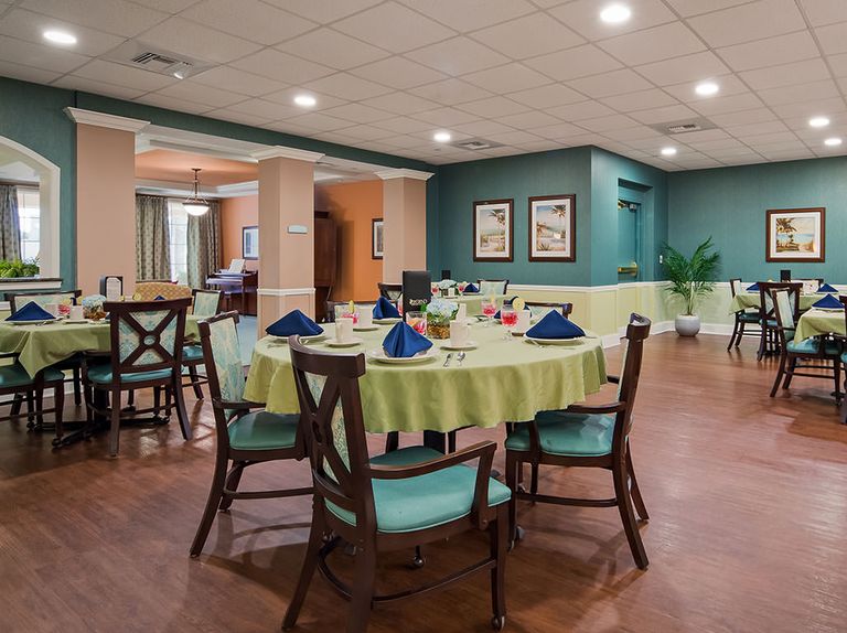 Senior residents enjoying in the dining hall of The Windsor of Palm Coast with elegant architecture.