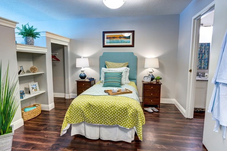 Interior design of a bedroom in Ridgeland Place senior living community featuring hardwood flooring and home decor.