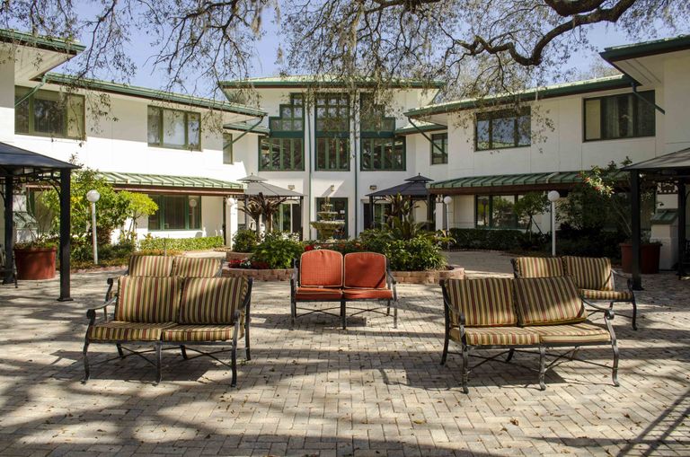 Architectural view of Weinberg Village senior living community with patio furniture.