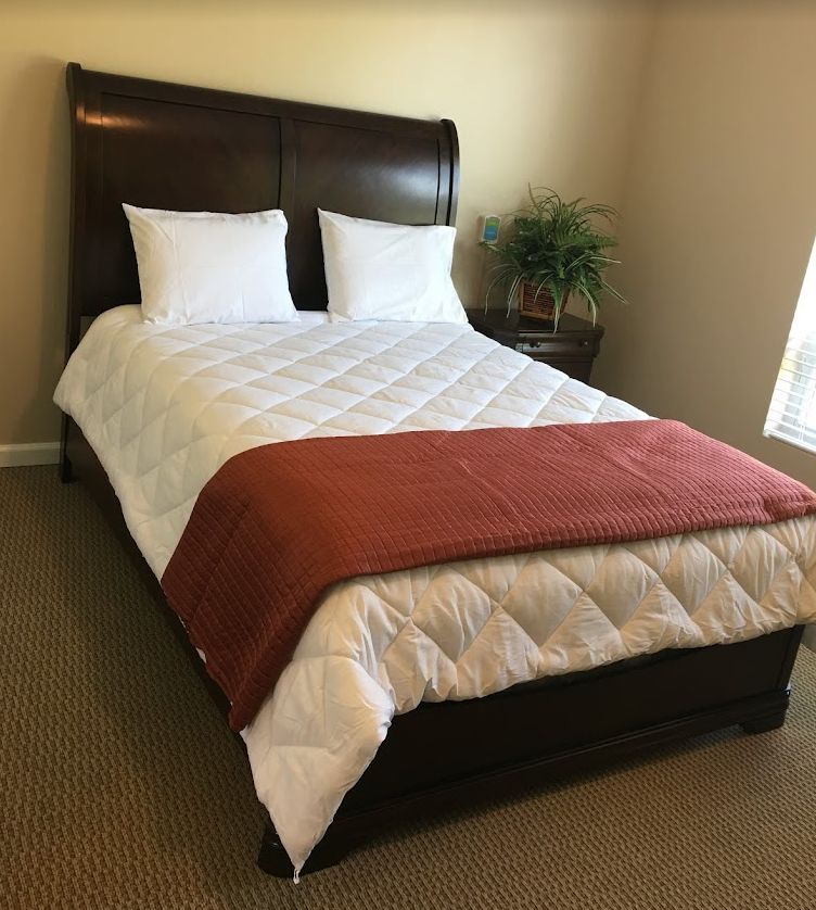 Comfortable bedroom setup with furniture and home decor in The Gardens of Waterford senior living community.