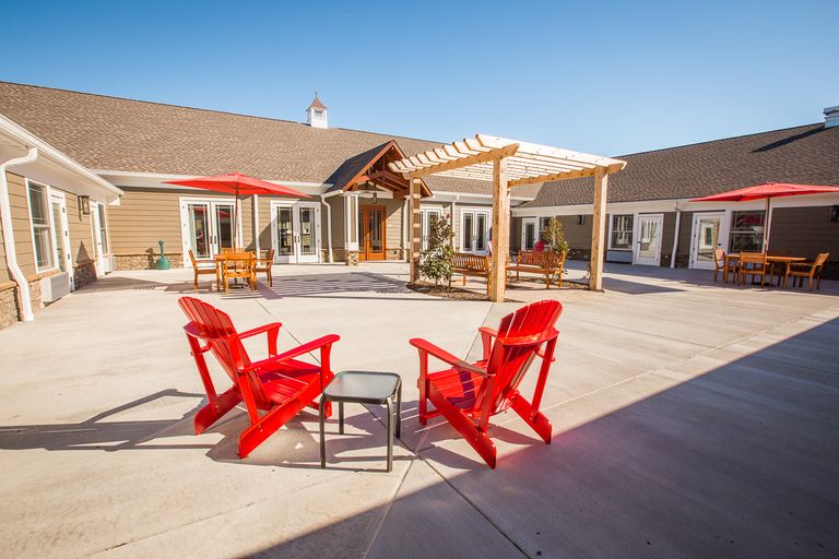 Senior living community house with patio furniture, indoor interior design, and outdoor pergola.