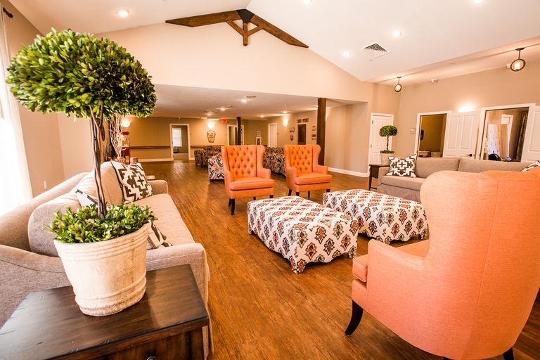 Interior design of a furnished living room in a senior living community with wooden decor.