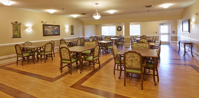 Interior view of Hickory Village senior living community featuring hardwood flooring and dining area.