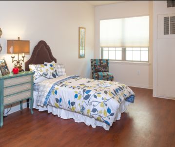 Interior view of a furnished bedroom at Poet's Walk Round Rock senior living community.