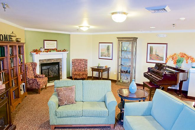 Interior view of Brookdale Pocatello senior living room with piano, fireplace, and home decor.